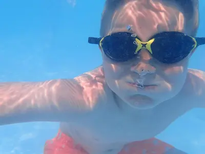 a young boy wearing sunglasses in the water at Holly Tree Hotel, Swimming Pool & Hot Tub in Glencoe