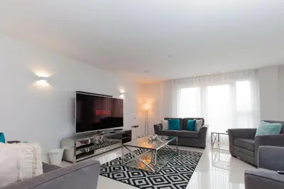 a living room with couches and a flat screen tv at Luxurious Central Edinburgh Apartment - Sleeps 6 in Edinburgh
