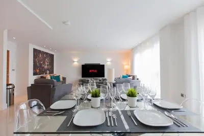 a dining room with a table and a living room at Luxurious Central Edinburgh Apartment - Sleeps 6 in Edinburgh