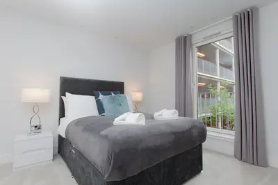 a bedroom with a large bed and a window at Luxurious Central Edinburgh Apartment - Sleeps 6 in Edinburgh