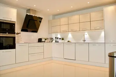 a white kitchen with white cabinets and appliances at Luxurious Central Edinburgh Apartment - Sleeps 6 in Edinburgh