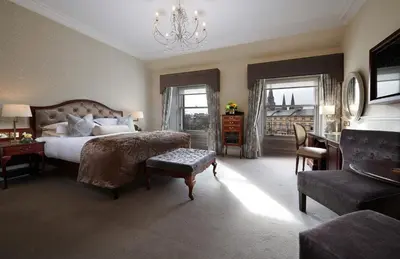 a bedroom with a large bed and a chandelier at The Bonham in Edinburgh