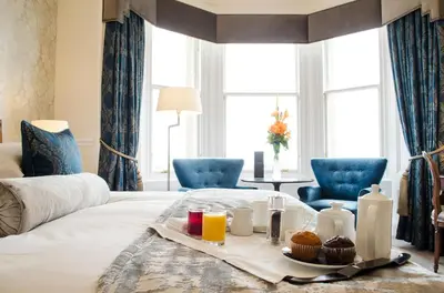 a hotel room with a tray of food on a bed at The Bonham in Edinburgh