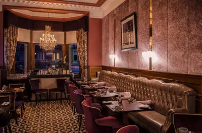 a restaurant with tables and chairs and a chandelier at The Bonham in Edinburgh