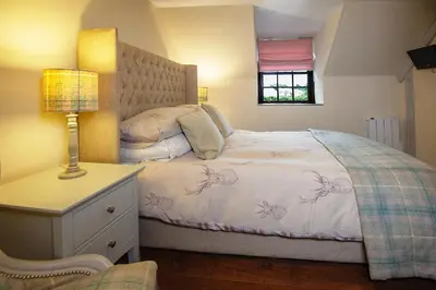 a bedroom with a bed and a lamp on a dresser at The Falls Of Dochart Inn in Killin