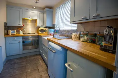 a kitchen with blue cabinets and a wooden counter top at The Falls Of Dochart Inn in Killin