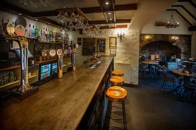 a bar with a wooden counter in a restaurant at The Falls Of Dochart Inn in Killin