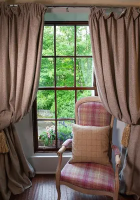 a chair with a pillow in front of a window at The Falls Of Dochart Inn in Killin