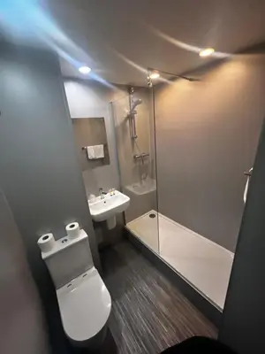 a bathroom with a toilet and a shower and a sink at Park Hotel in Falkirk