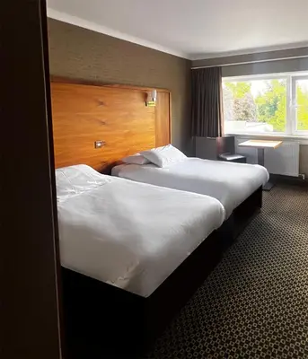 a hotel room with two beds and a window at Park Hotel in Falkirk