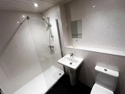 a bathroom with a shower and a toilet and a sink at Park Hotel in Falkirk