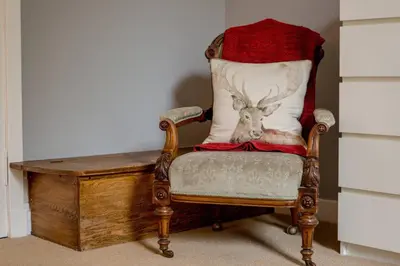 a chair with a pillow with a deer head on it at JOIVY Spacious Apt in New Town Prime Location in Edinburgh