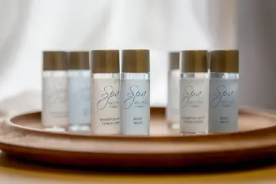 four bottles of sunscreen sitting on a wooden shelf at JOIVY Spacious Apt in New Town Prime Location in Edinburgh
