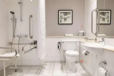a white bathroom with a toilet and a sink at DoubleTree by Hilton Edinburgh Airport in Ingliston