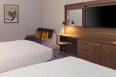 a hotel room with two beds and a television at DoubleTree by Hilton Edinburgh Airport in Ingliston