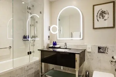 a bathroom with a sink and a shower at The Caledonian Edinburgh, Curio Collection by Hilton in Edinburgh