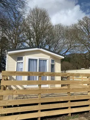 a small yellow house behind a wooden fence at Brookwood Sea View 14 in Dunoon
