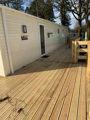 a large wooden deck with a building with a door at Brookwood Sea View 14 in Dunoon