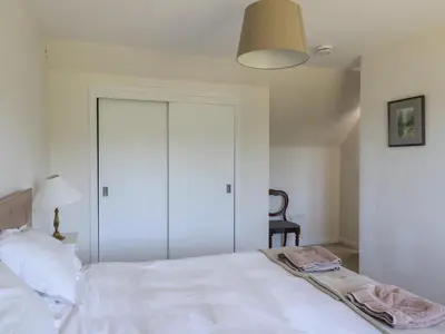 a bedroom with a white bed and a chair at Sobrachan in Braevallich