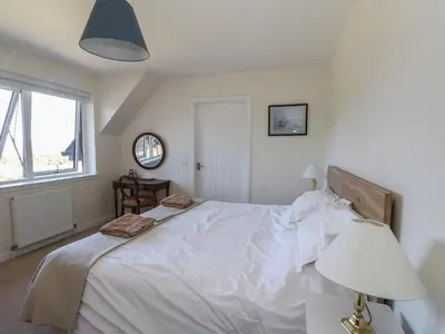 a bedroom with a large white bed with a lamp at Sobrachan in Braevallich
