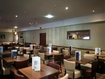 a restaurant with tables and chairs in a room at King Robert Hotel in Stirling