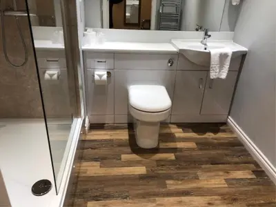 a bathroom with a toilet and a sink and a shower at King Robert Hotel in Stirling