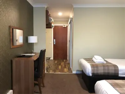 a hotel room with a desk and a bed at King Robert Hotel in Stirling