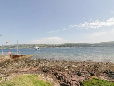 a large body of water with a boat in the distance at MACS Place in Largs