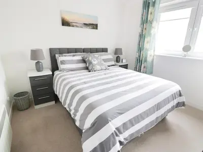 a bedroom with a black and white bed and a window at MACS Place in Largs