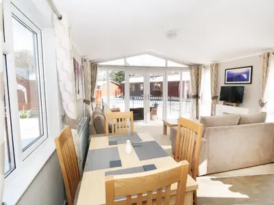 a living room with a table and chairs and a couch at 32 Cruachan Lodge in Auchterarder