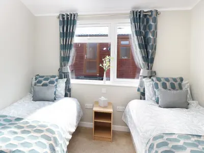 a bedroom with two beds and a window at 32 Cruachan Lodge in Auchterarder