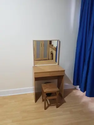 a dressing table with a mirror and a stool at Bentinck Street Ground Floor Apartment in Glasgow