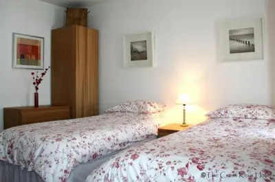 a bedroom with two beds and a table with a lamp at The Cross Keys Hotel in New Galloway