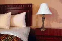 a lamp on a table next to a bed at The Cross Keys Hotel in New Galloway