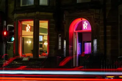 a building with neon signs on the front of it at Revolver Edinburgh in Edinburgh