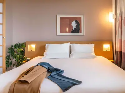 a bedroom with a bed with a scarf on it at Novotel Edinburgh Park in Edinburgh