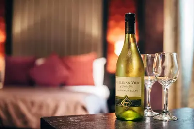 a bottle of wine sitting on a table with two glasses at The Torrance Hotel in East Kilbride