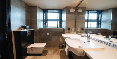 a bathroom with two sinks and a toilet at The Torrance Hotel in East Kilbride