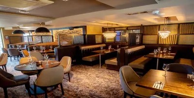 a restaurant with tables and chairs in a room at The Torrance Hotel in East Kilbride