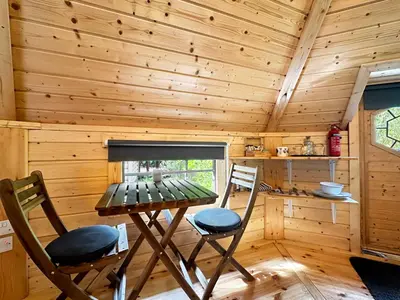 a room with a table and two chairs in a cabin at Aos Sí Lodges in Ballachulish