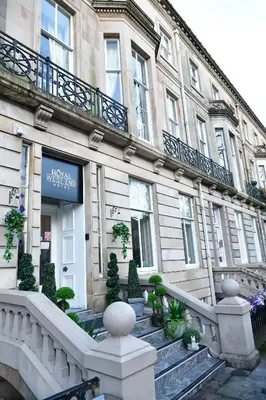a building with stairs and plants in front of it at Royal West End Hotel in Glasgow