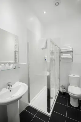 a bathroom with a shower and a sink and a toilet at Royal West End Hotel in Glasgow