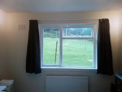 a window with a view of a green yard at Homestay, Number 29, Dunollie in Oban