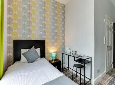 a bedroom with a bed and a accent wall at Lost Guest House Stirling in Stirling
