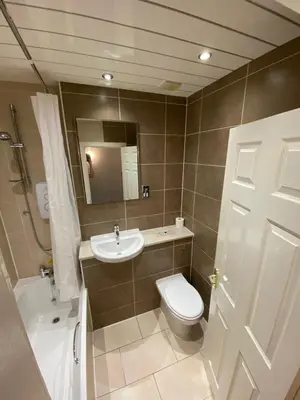 a bathroom with a toilet and a sink and a mirror at Lost Guest House Stirling in Stirling