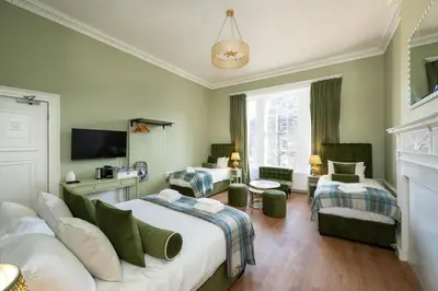 a bedroom with two beds and a living room with a tv at No. 53 Frederick Street in Edinburgh