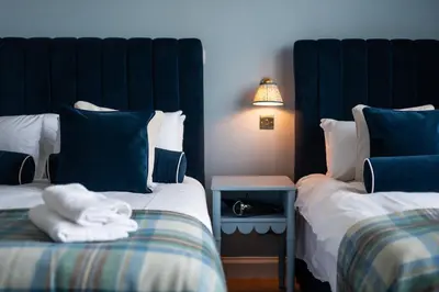 a room with two beds with blue and white pillows at No. 53 Frederick Street in Edinburgh