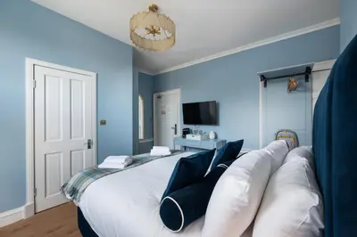a bedroom with a large white bed with blue walls at No. 53 Frederick Street in Edinburgh