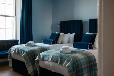 two beds in a hotel room with blue walls at No. 53 Frederick Street in Edinburgh