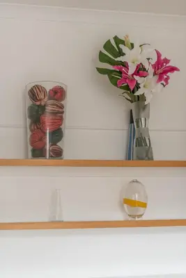 a shelf with a vase with flowers on it at 3 bed overlooking meadows park in Edinburgh